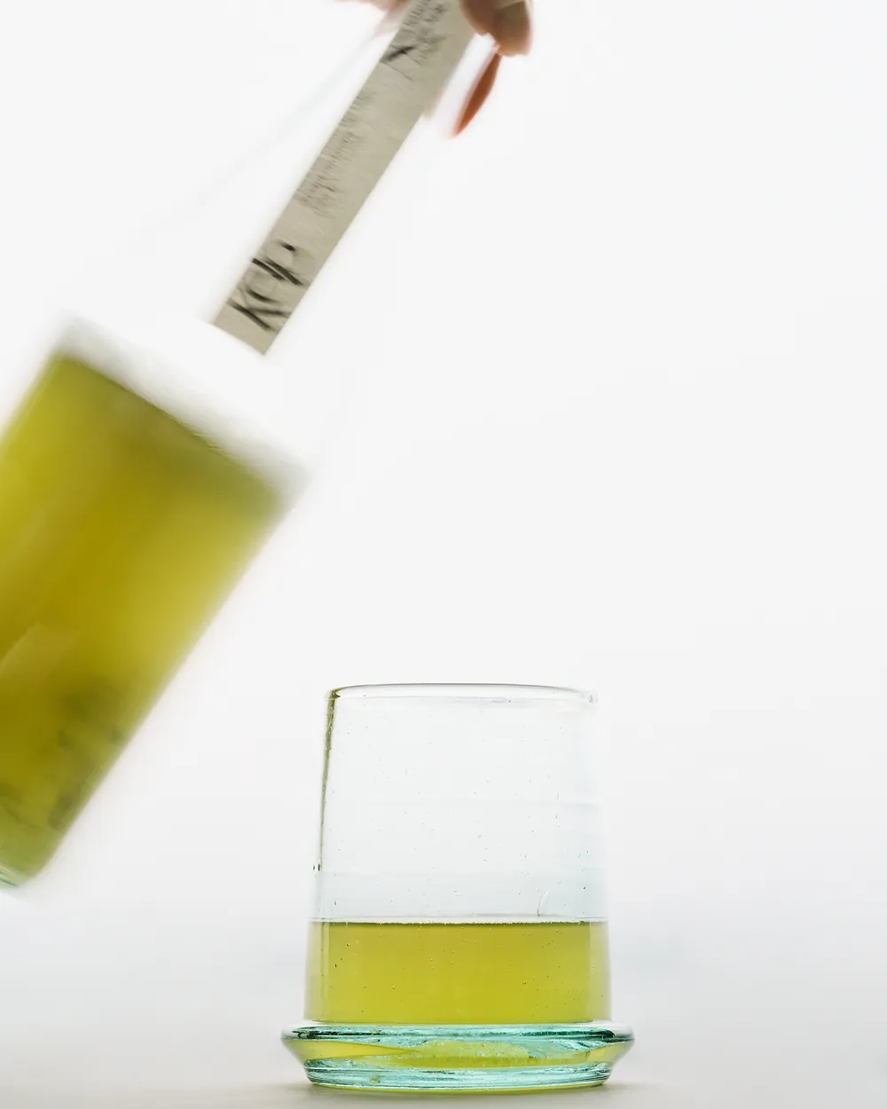 Sea lettuce kombucha being poured into a small glass